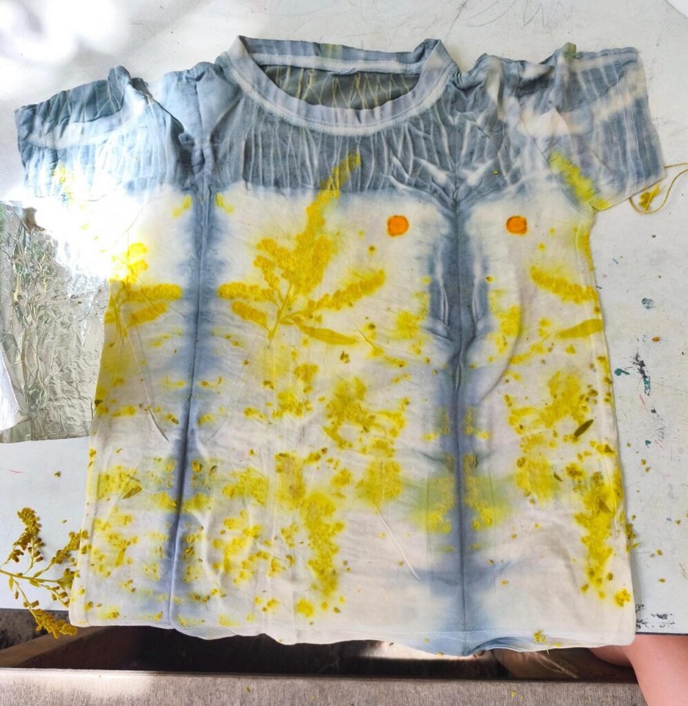 Fertiges Ecoprint-T-Shirt mit gelben Blattabdrücken und blaugrauen Mustern