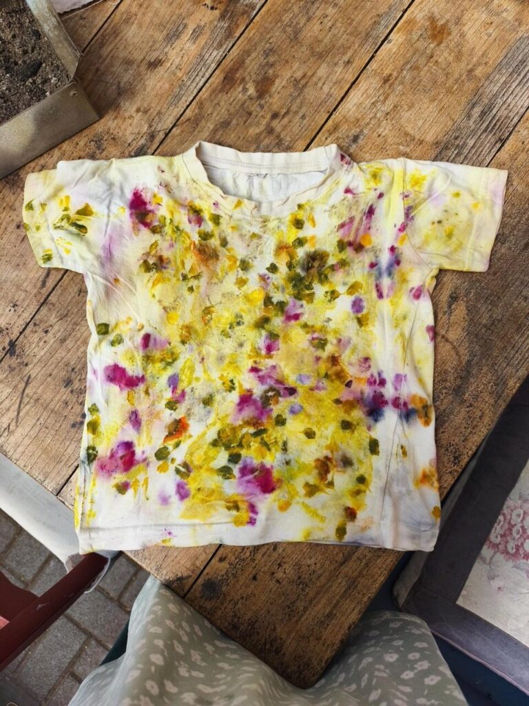 Fertiges Ecoprint-T-Shirt mit gelben, grünen und violetten Pflanzenabdrücken